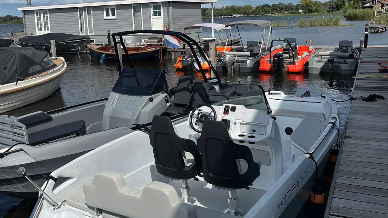 La Hydra 530 e altre imbarcazioni in polietilene ormeggiate presso un molo su un lago nella regione del Benelux.