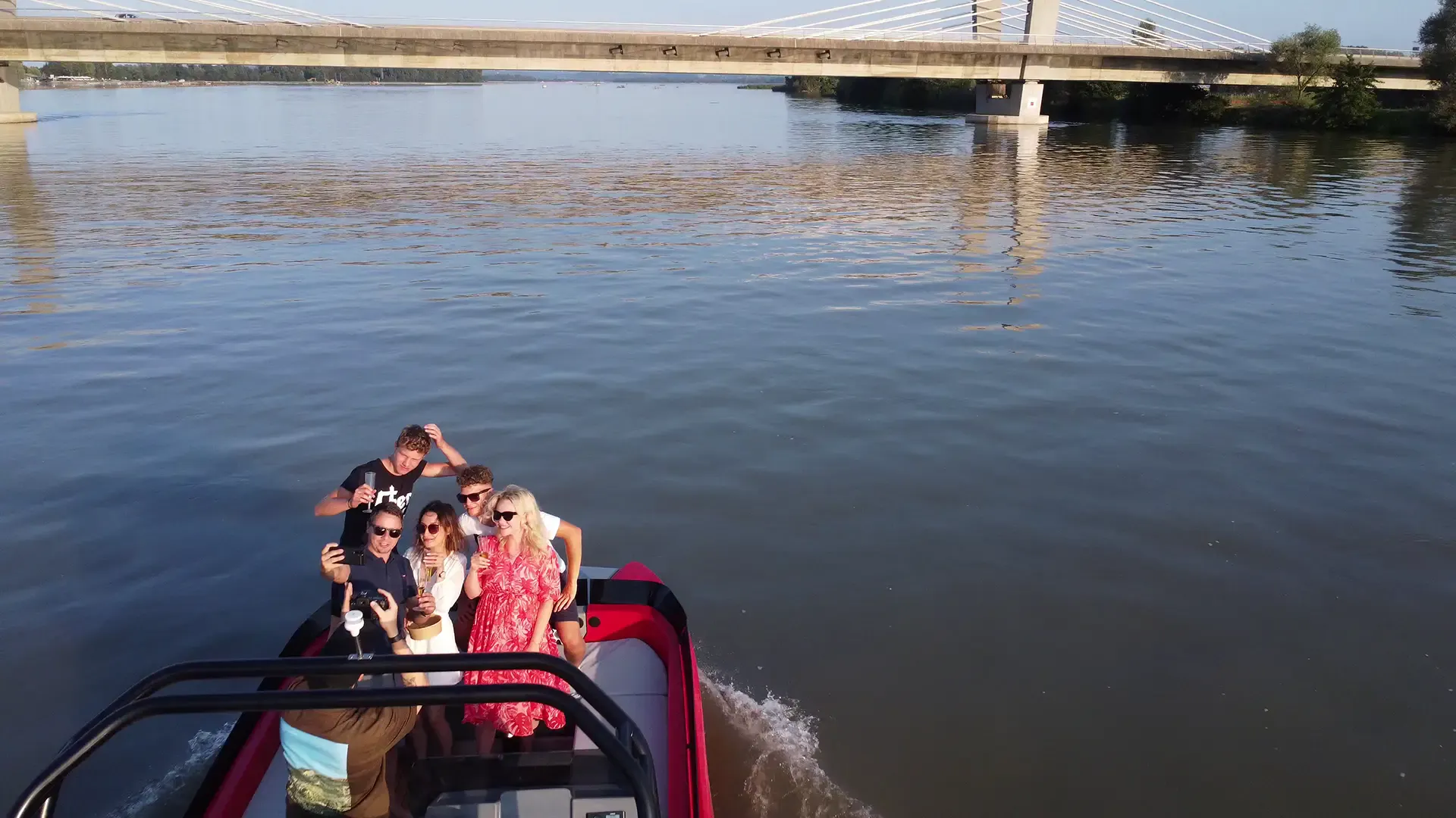 Un grupo de jóvenes tomándose una selfie en un barco en una fiesta de cumpleaños.